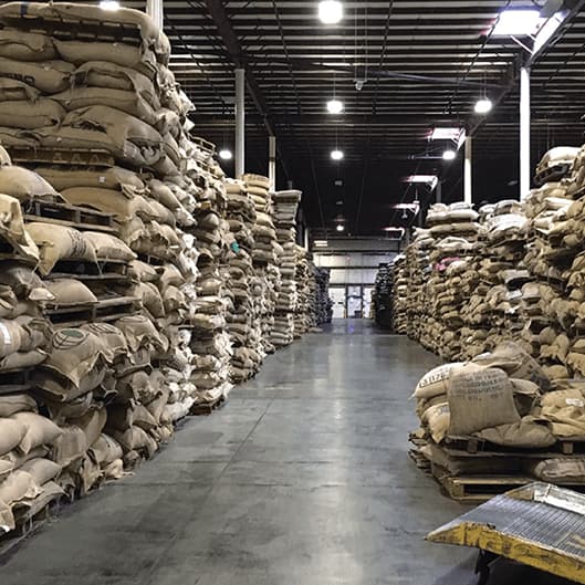 Warehouse with stacked bags of green coffee